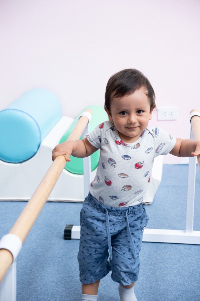 Pequeño gymnasta en barras paralelas