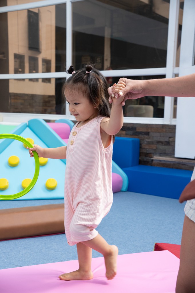 Niña caminando con apoyo en Fly Gym